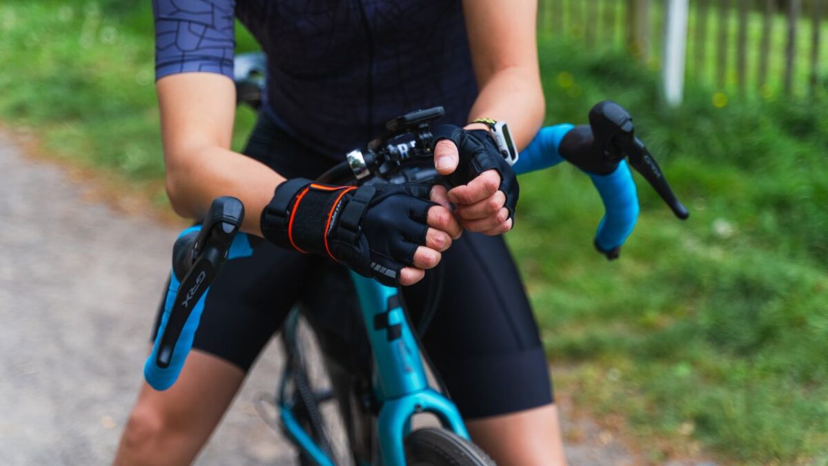 Offres Close-up of a cyclist's hands in black gloves gripping the handlebars of a gravel bike.
